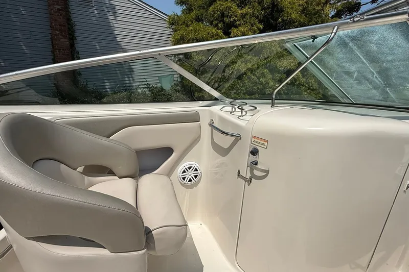 Slide: The Image of 2005 Sea Ray 270 Sundeck interior with beige seating and sleek dashboard design. - 9