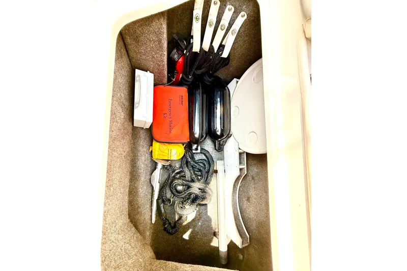 Slide: The Image of Storage compartment of a 2005 Sea Ray 270 Sundeck with marine safety equipment. - 25
