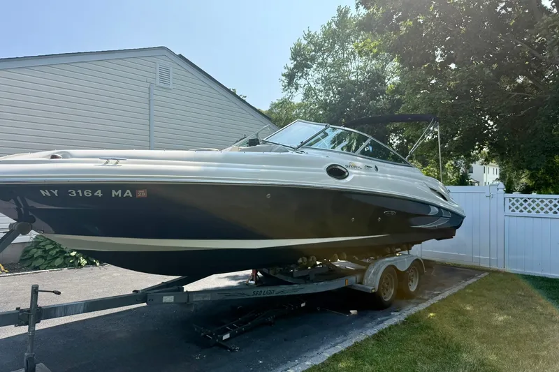 Slide: The Image of 2005 Sea Ray 270 Sundeck boat on trailer, parked in driveway. - 2