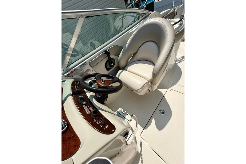 Slide: The Image of 2005 Sea Ray 270 Sundeck helm with steering wheel and cushioned captain's chair. - 20