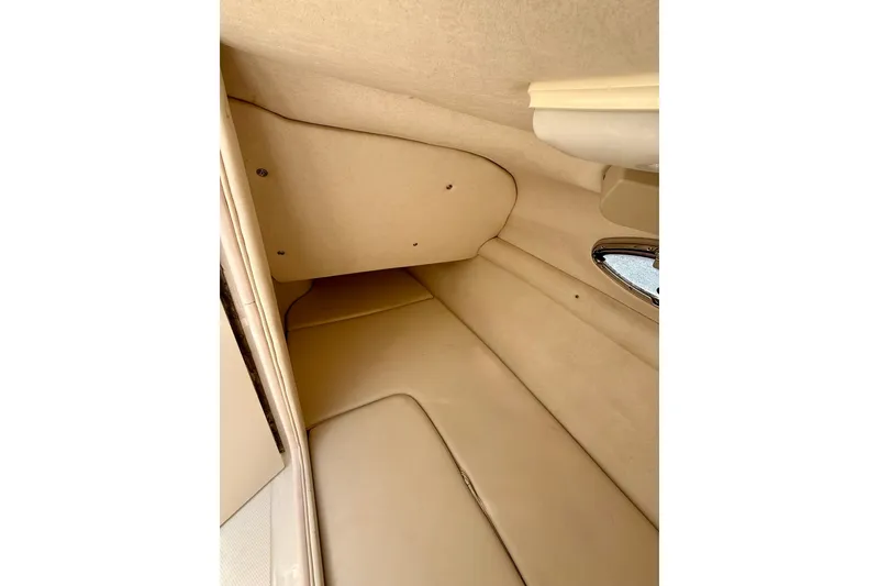 Slide: The Image of Interior cabin of 2005 Sea Ray 270 Sundeck boat, featuring beige upholstery. - 12