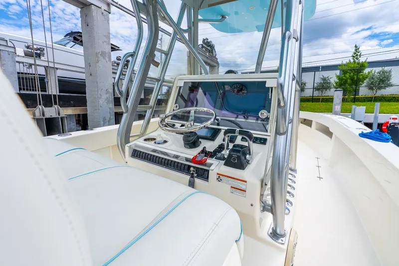 Slide: The Image of 2020 SeaVee 340Z boat cockpit with steering wheel and controls, docked outdoors. - 41
