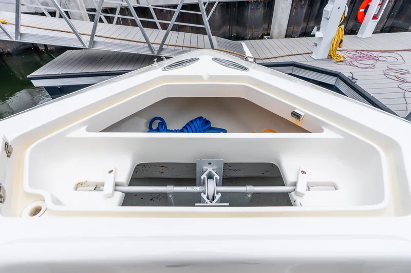 Slide: The Image of 2020 SeaVee 340Z boat anchor compartment with blue rope and dock background. - 32