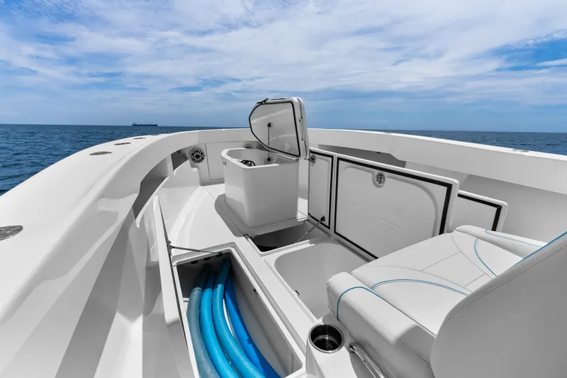 Slide: The Image of 2020 SeaVee 340Z boat interior with open storage, ocean view, and clear sky. - 23