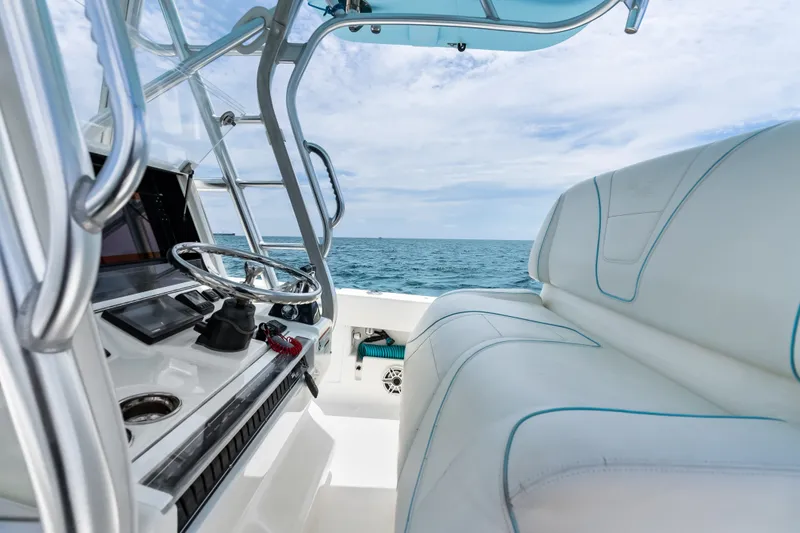 Slide: The Image of 2020 SeaVee 340Z boat interior with steering wheel, ocean view, and cushioned seating. - 50