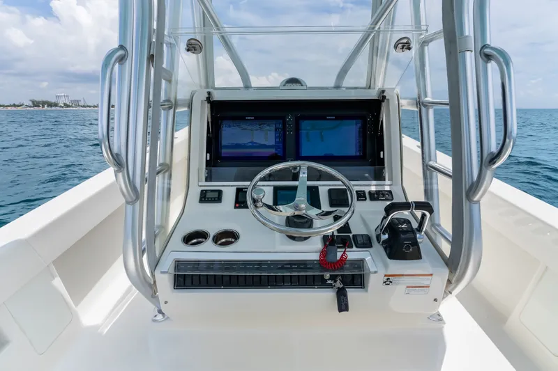 Slide: The Image of 2020 SeaVee 340Z boat helm with dual screens and steering wheel on open water. - 54