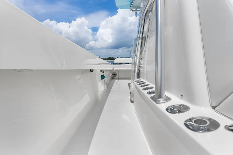 Slide: The Image of 2020 SeaVee 340Z boat deck with rod holders, under a blue sky with clouds. - 24