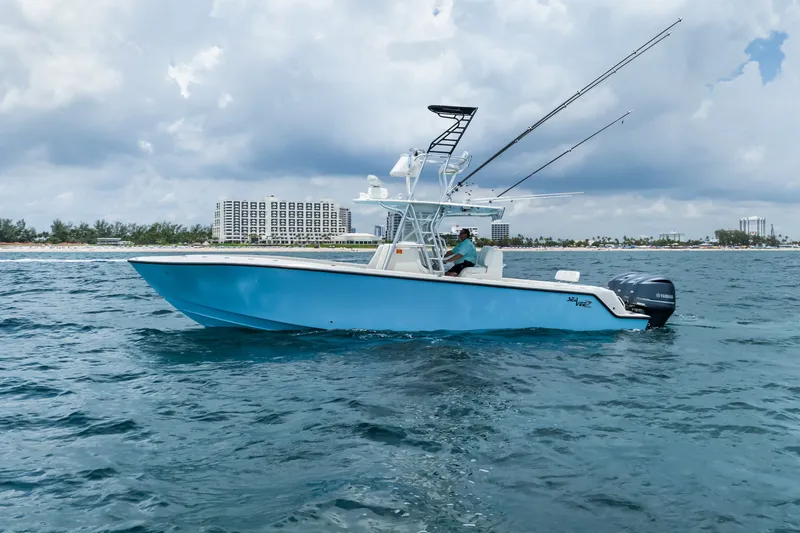 Slide: The Image of 2020 SeaVee 340Z boat on ocean, with fishing rods and city skyline in background. - 2