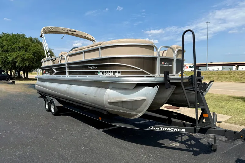 The Image of 2018 Sun Tracker Party Barge 24 XP3 pontoon boat on trailer, parked outdoors. - 0