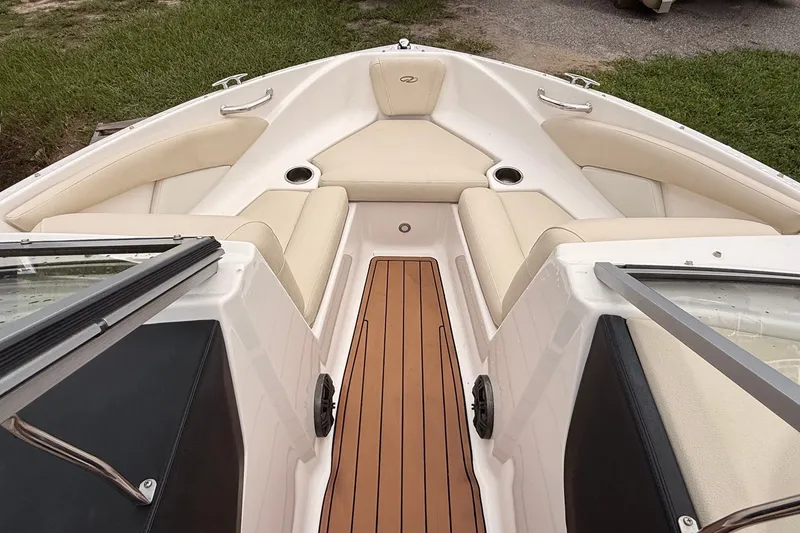 Slide: The Image of 2018 Regal 1900 ES Bowrider interior with beige seating and wooden flooring. - 2