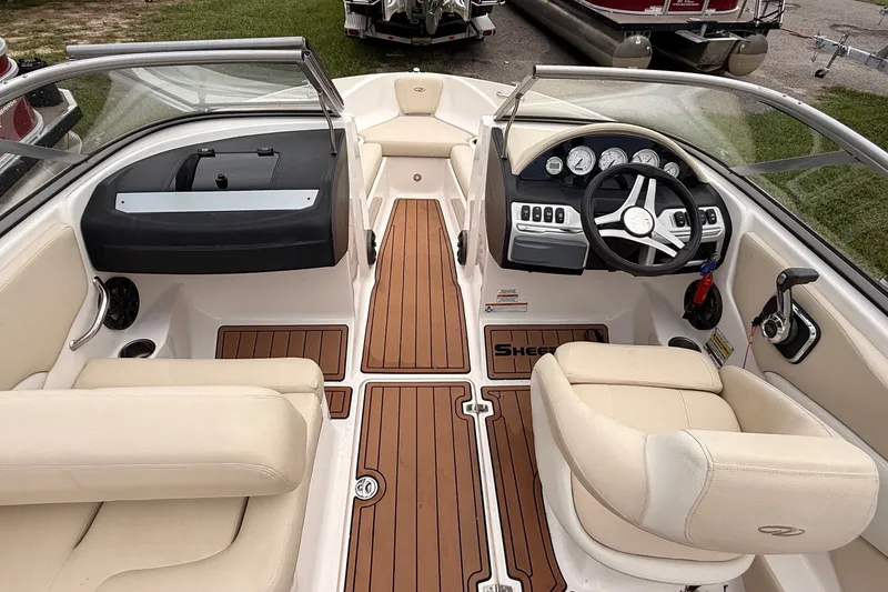 Slide: The Image of 2018 Regal 1900 ES Bowrider interior with beige seating and wooden flooring. - 8