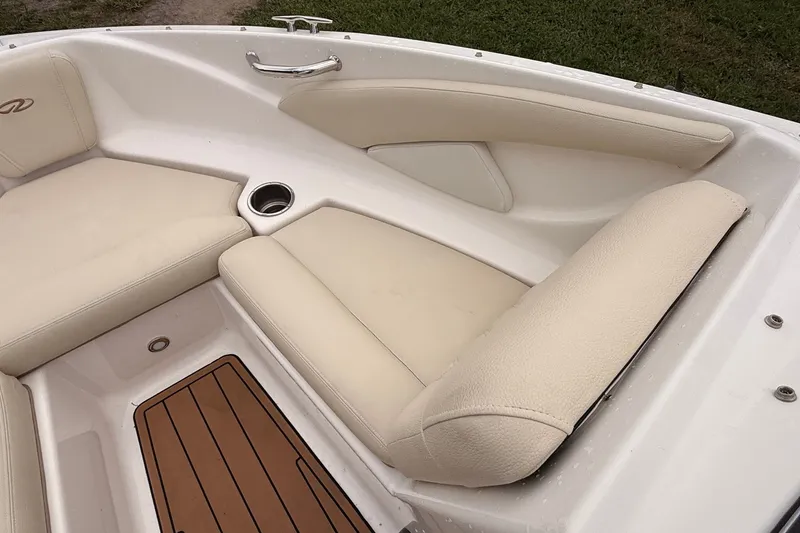 Slide: The Image of 2018 Regal 1900 ES Bowrider interior with beige seating and wood accents. - 5