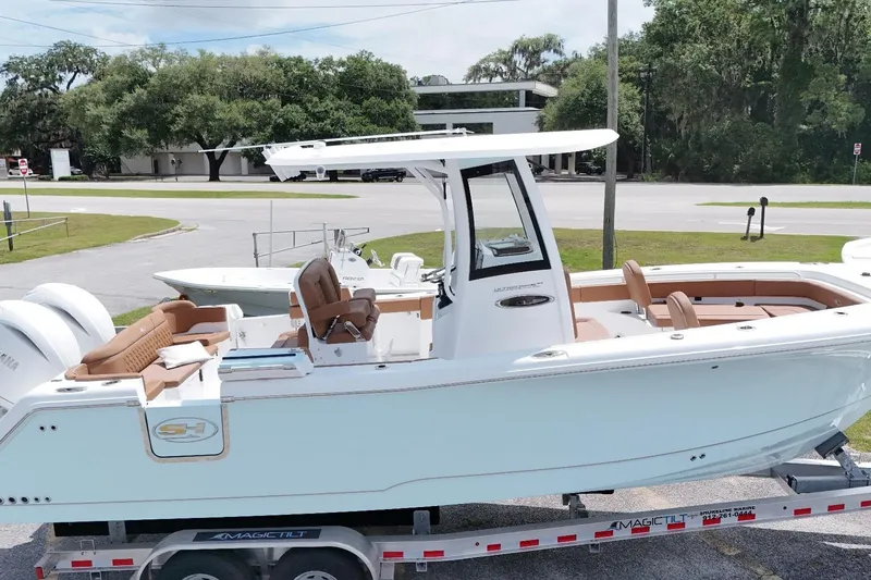 Slide: The Image of 2027 Sea Hunt Ultra 265SE boat on trailer, featuring sleek design and spacious seating. - 16