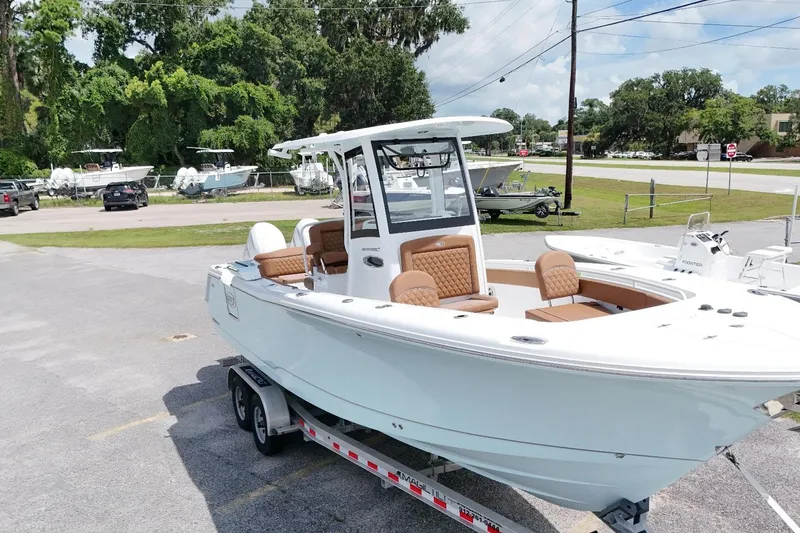 Slide: The Image of 2027 Sea Hunt Ultra 265SE boat on trailer, parked outdoors, showcasing sleek design and seating. - 15