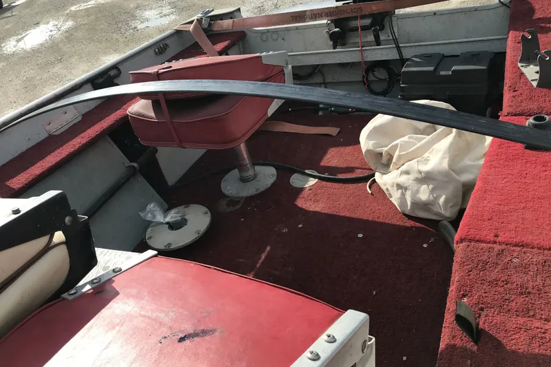 Slide: The Image of Interior of a 1989 Lund 16 Pike SS boat with red seating and carpet. - 25