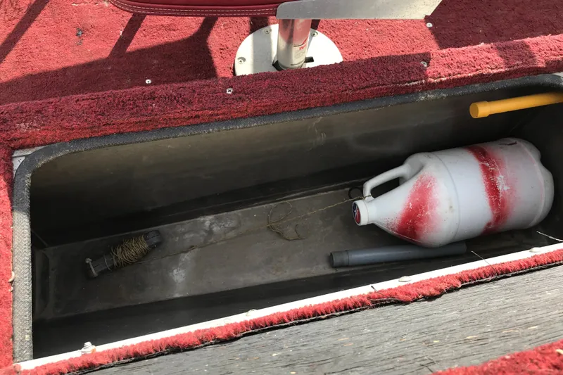 Slide: The Image of Storage compartment of a 1989 Lund 16 Pike SS boat with red carpet and equipment. - 23