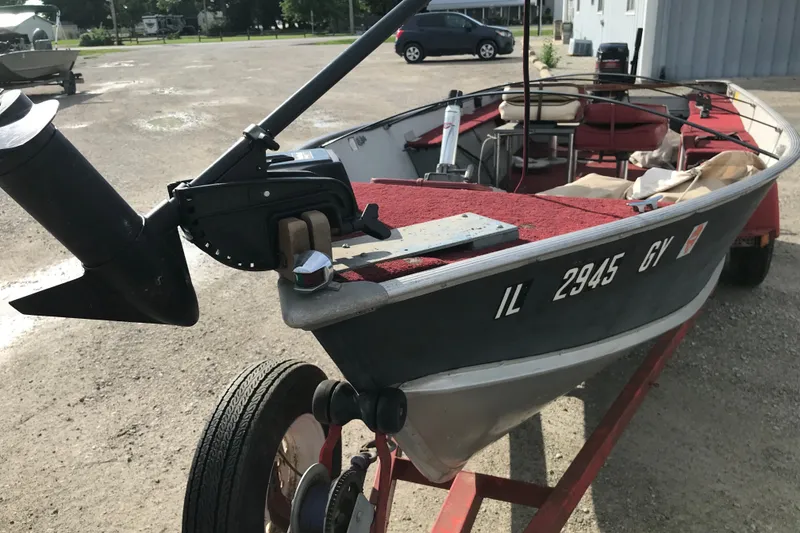 Slide: The Image of 1989 Lund 16 Pike SS boat on trailer, parked outdoors, with visible registration number. - 22