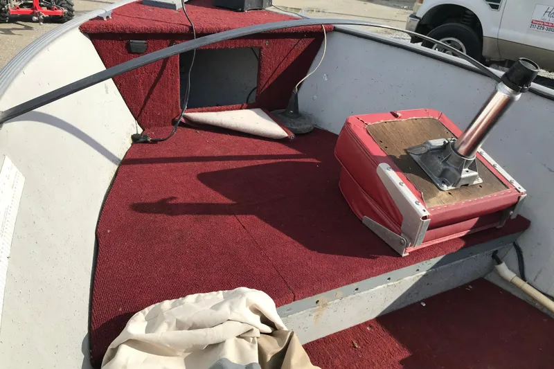 Slide: The Image of 1989 Lund 16 Pike SS boat interior with red carpet and seat base. - 27