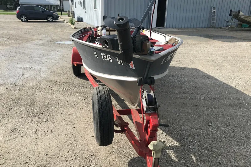Slide: The Image of 1989 Lund 16 Pike SS boat on trailer in gravel lot. - 17