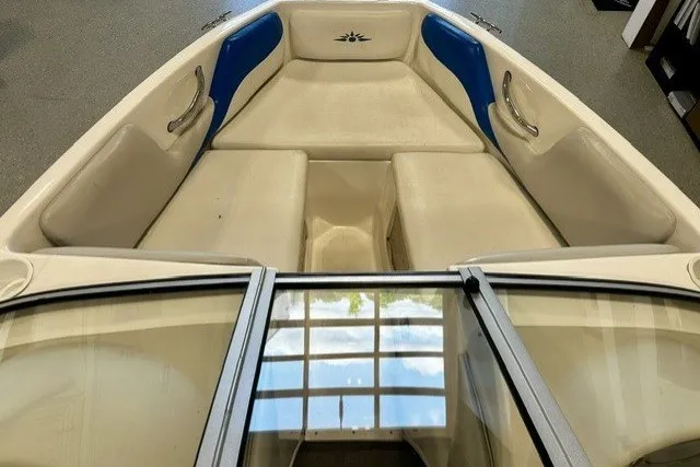 Slide: The Image of 2007 Mariah SX18 boat interior with beige and blue seating, viewed from the bow. - 14