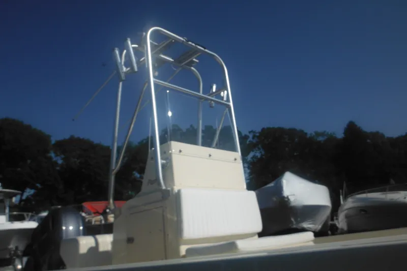 Slide: The Image of 2001 Parker 1801 Center Console boat with T-top, docked under clear blue sky. - 11