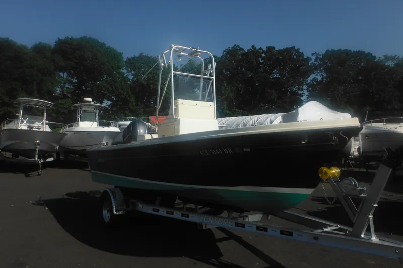Slide: The Image of 2001 Parker 1801 Center Console boat on trailer, surrounded by trees and other boats. - 2