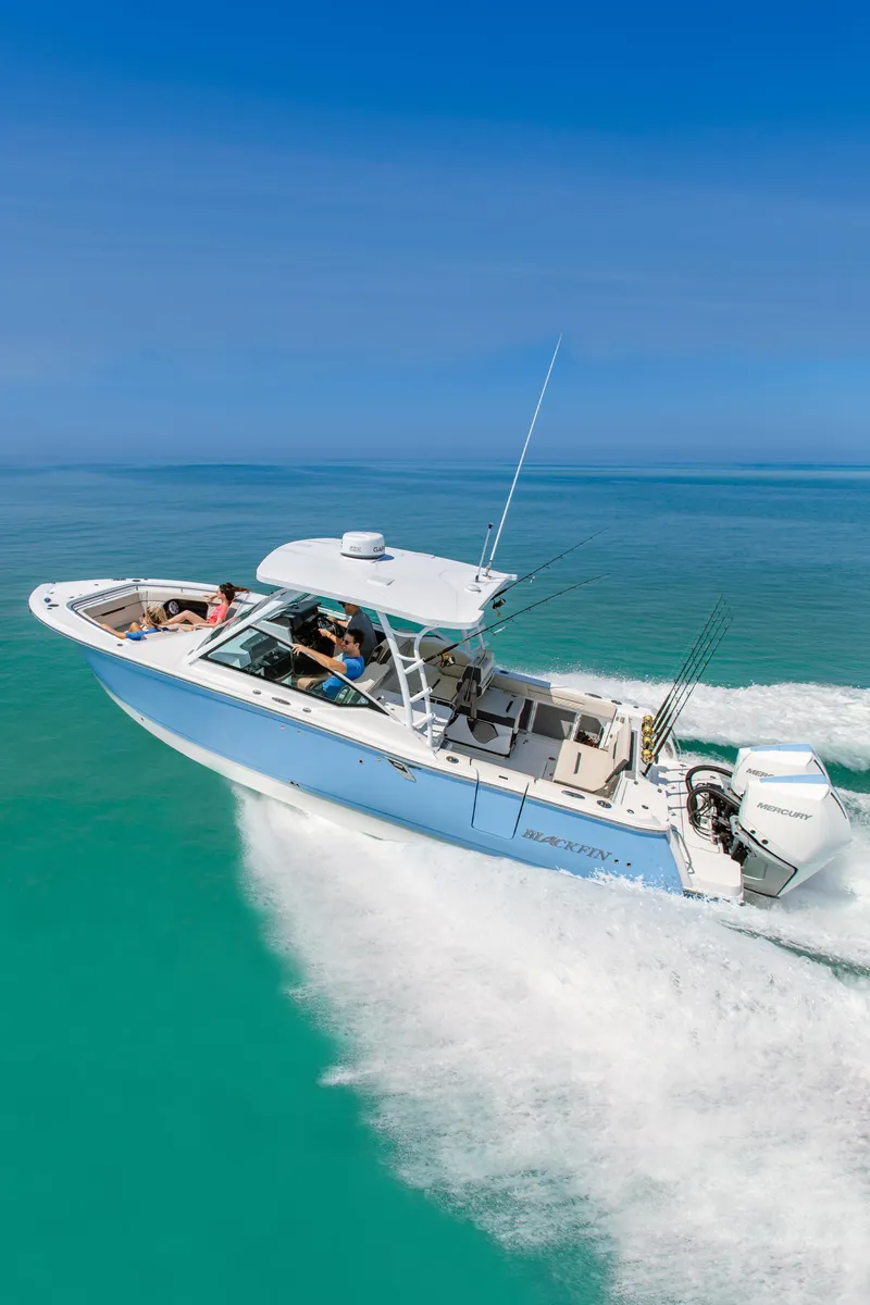 Slide: The Image of 2026 Blackfin 302 DC boat cruising on turquoise water under clear blue sky. - 1