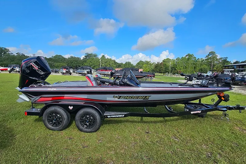 The Image of 2027 Phoenix 721 ZXL bass boat on trailer, parked on grass under blue sky. - 1