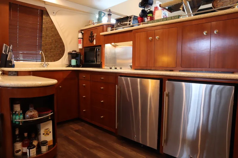 Slide: The Image of Luxurious kitchen interior of 1999 Carver Yacht Voyager 530 with wooden cabinets and modern appliances. - 11