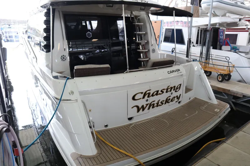 Slide: The Image of 1999 Carver Yacht Voyager 530 named "Chasing Whiskey" docked in a marina. - 6