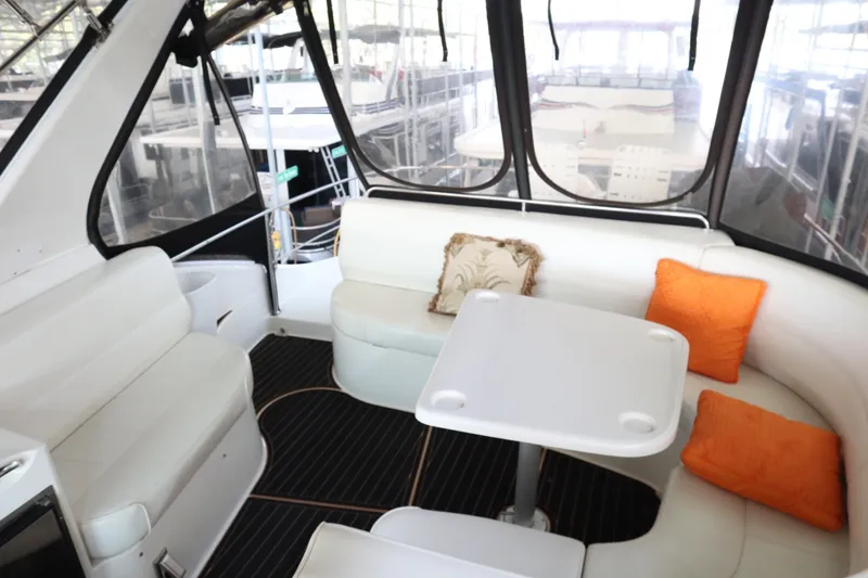 Slide: The Image of Interior of 1999 Carver Yacht Voyager 530 with white seating and orange cushions. - 32
