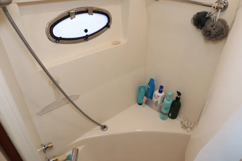 Slide: The Image of Shower area in 1999 Carver Yacht Voyager 530 with toiletries and porthole window. - 17