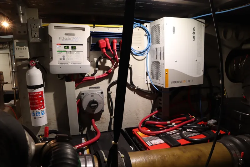 Slide: The Image of Engine room of 1999 Carver Yacht Voyager 530 with electrical systems and fire extinguisher. - 48
