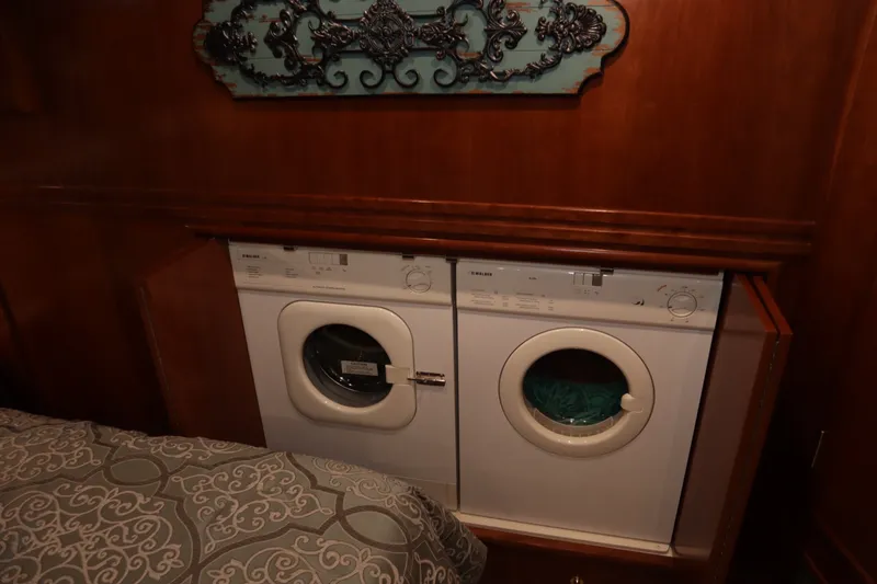 Slide: The Image of Laundry area inside 1999 Carver Yacht Voyager 530, featuring washer and dryer units. - 16