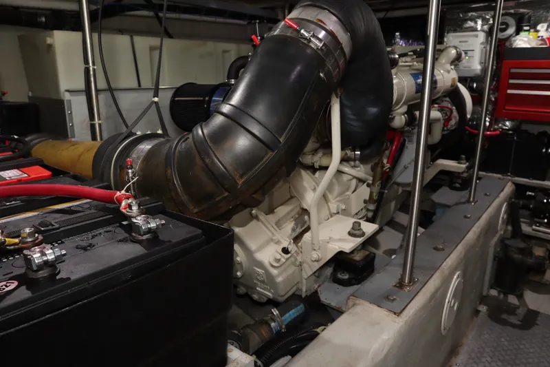 Slide: The Image of Engine room of a 1999 Carver Yacht Voyager 530, showcasing mechanical components and battery. - 28