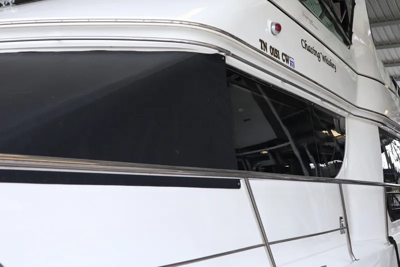 Slide: The Image of 1999 Carver Yacht Voyager 530 docked, showcasing sleek design and reflective windows. - 7