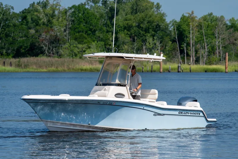 Slide: The Image of 2018 Grady-White Fisherman 216 boat cruising on a serene lake with lush greenery. - 12