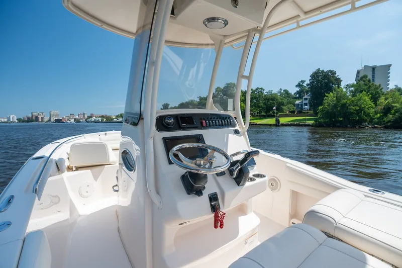Slide: The Image of 2018 Grady-White Fisherman 216 boat on a scenic river, featuring a sleek helm design. - 21
