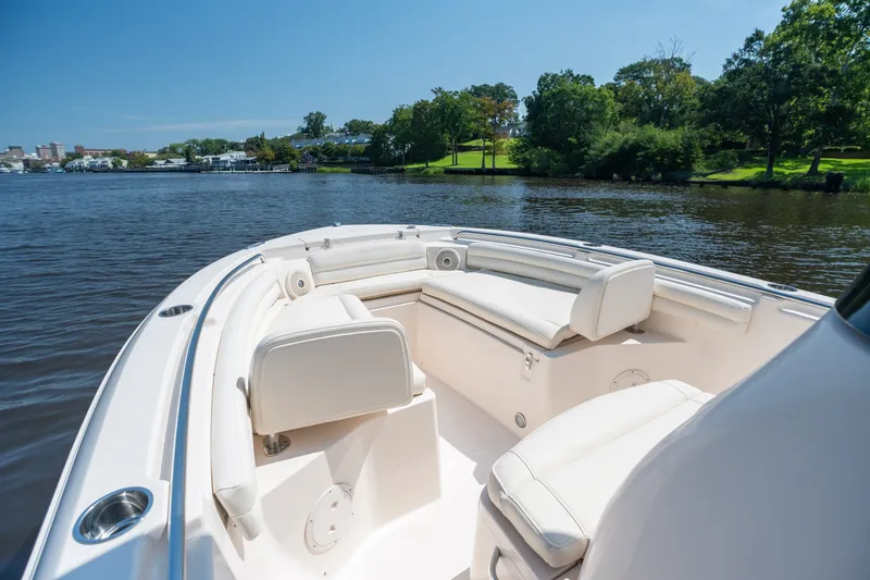 Slide: The Image of 2018 Grady-White Fisherman 216 boat interior with white seating on a calm river. - 25