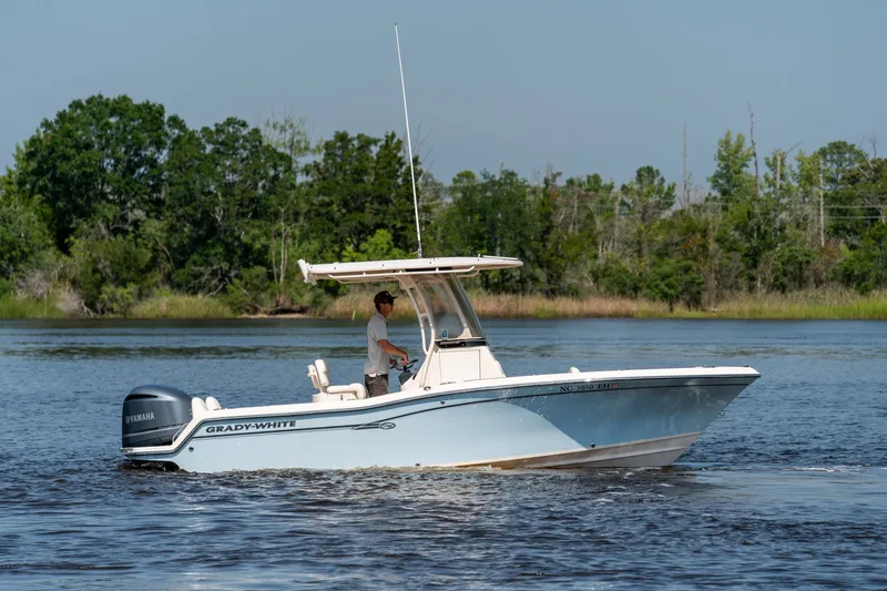 The Image of 2018 Grady-White Fisherman 216 boat cruising on a serene lake with lush greenery. - 0