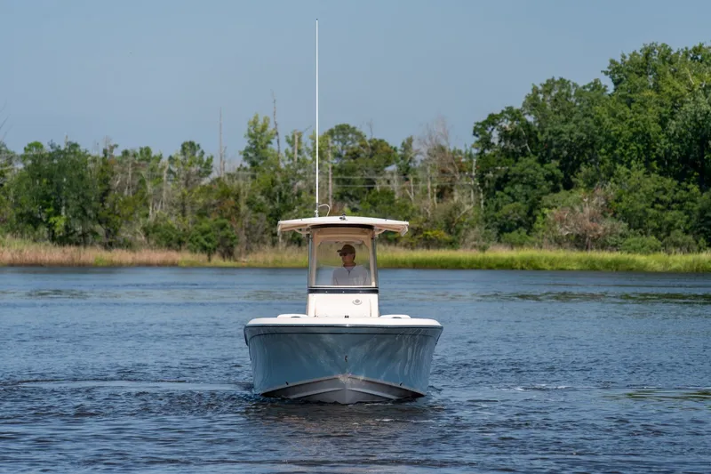 Slide: The Image of 2018 Grady-White Fisherman 216 boat cruising on a serene lake with lush greenery. - 14