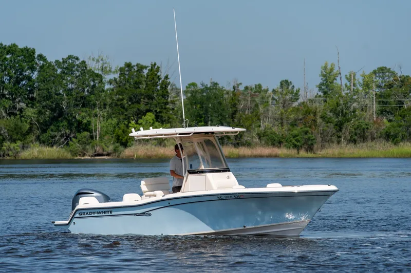 Slide: The Image of 2018 Grady-White Fisherman 216 boat cruising on a calm lake with lush green trees. - 1