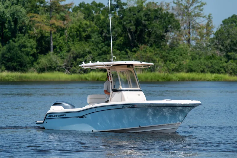 Slide: The Image of 2018 Grady-White Fisherman 216 boat cruising on a serene lake with lush greenery. - 10