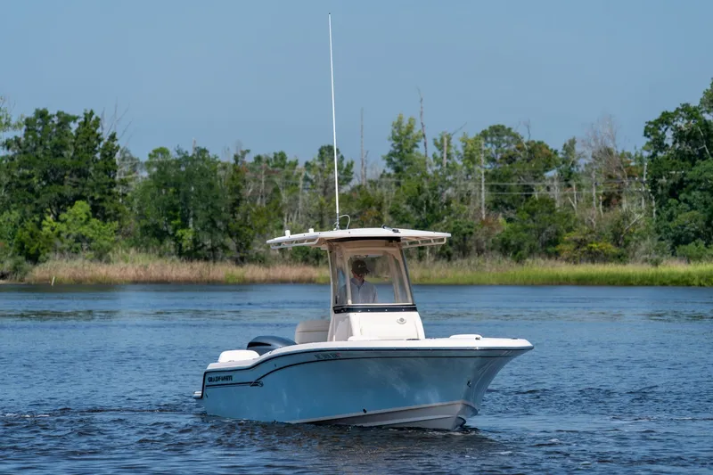 Slide: The Image of 2018 Grady-White Fisherman 216 boat cruising on a serene lake with lush greenery. - 2