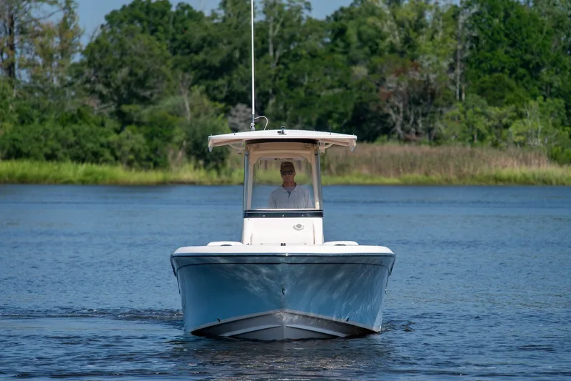 Slide: The Image of 2018 Grady-White Fisherman 216 boat cruising on a serene lake with lush greenery. - 11