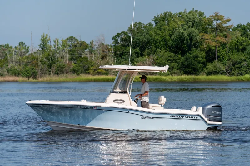 Slide: The Image of 2018 Grady-White Fisherman 216 boat cruising on a calm lake with lush green shoreline. - 4