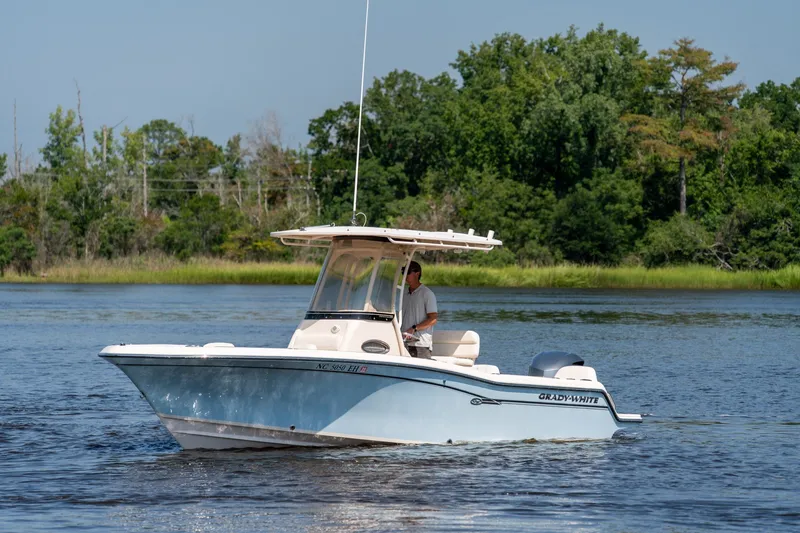 Slide: The Image of 2018 Grady-White Fisherman 216 boat cruising on a serene lake with lush greenery. - 3