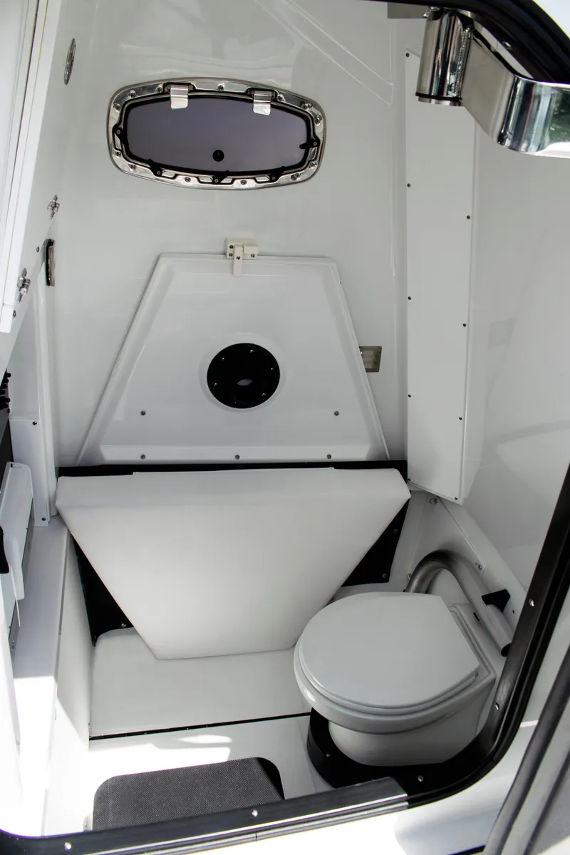 Slide: The Image of 2026 Blackfin 302 CC boat interior with compact marine toilet and porthole. - 17