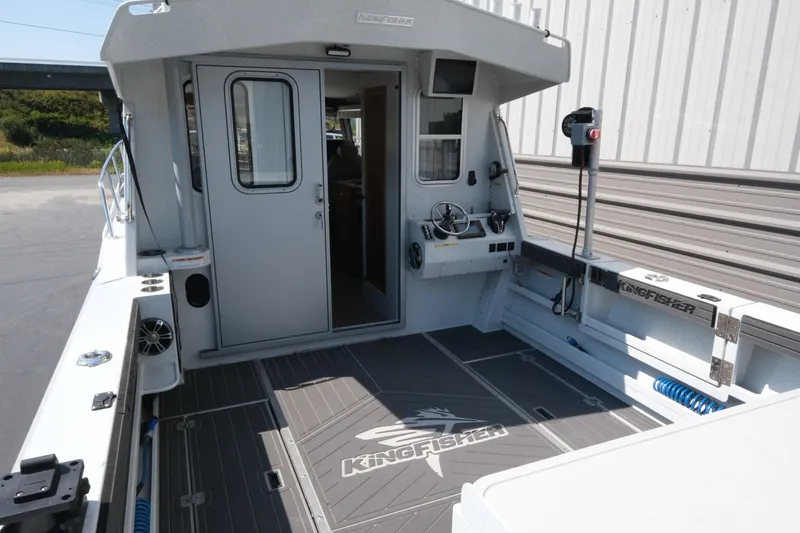 Slide: The Image of 2022 KingFisher 3425 GFX Offshore boat interior with steering console and spacious deck. - 6