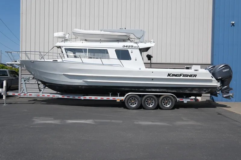 Slide: The Image of 2022 KingFisher 3425 GFX Offshore boat on trailer, parked outside a building. - 2
